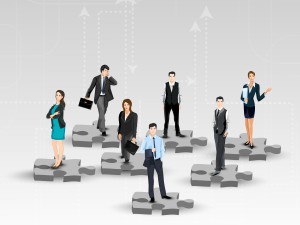 Business people stood on puzzle pieces